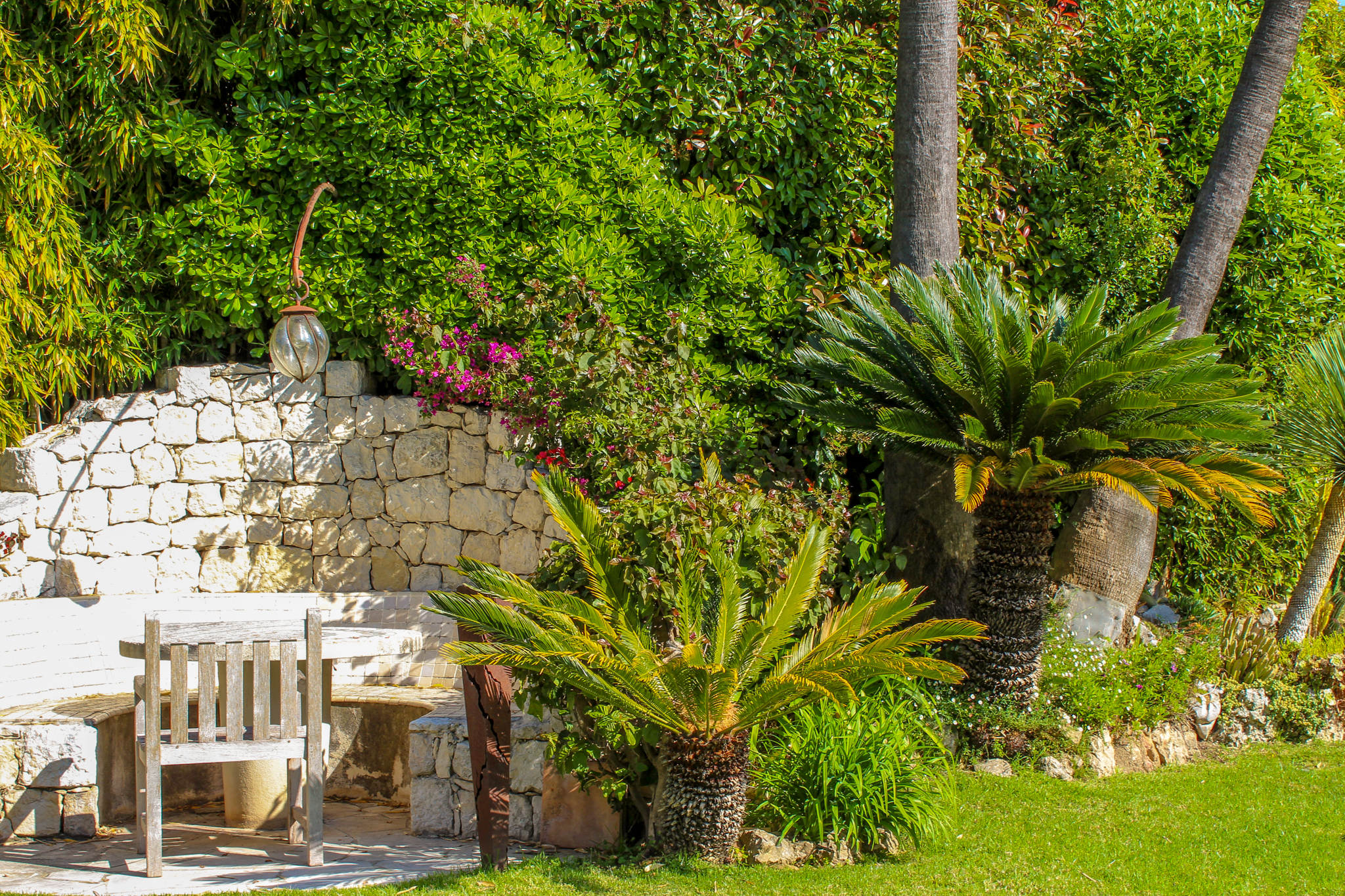 Jardin d'été avec mur en pierre et table
